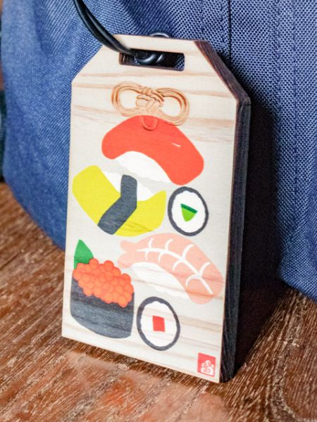 Etiqueta de equipaje de madera con forma de amuleto japonés